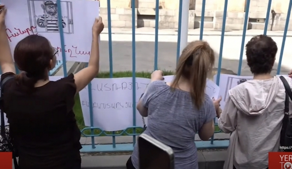 Плакаты с надписью «Свобода политзаключенным» на воротах офиса ООН (видео)